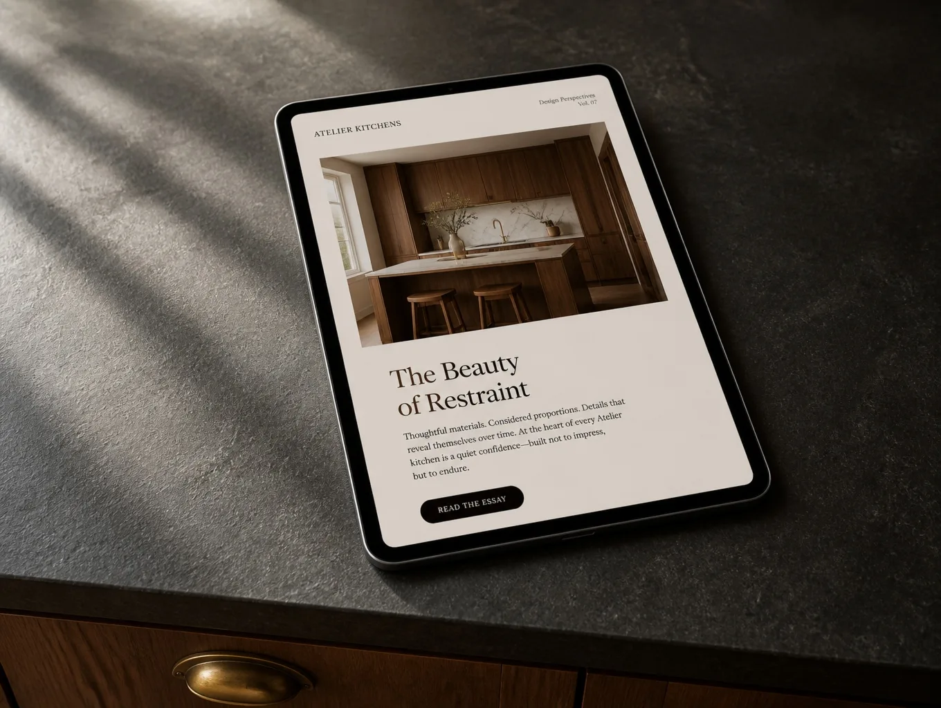 A tablet propped on a soapstone counter showing a kitchen company email designed like a magazine spread